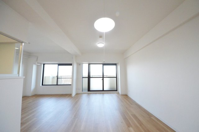 己斐本町コープマンションの居間・リビング|東南向きで陽当たりが良く、窓の多いリビング空間。オープンタイプの対面式キッチンでリビングが隅まで見渡せます。キッチンにいながら小さなお子様にも目が届き安心です。