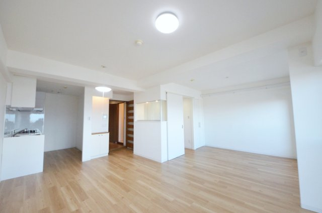 己斐本町コープマンションの居間・リビング|東南向きで陽当たりが良く、窓の多いリビング空間。オープンタイプの対面式キッチンでリビングが隅まで見渡せます。キッチンにいながら小さなお子様にも目が届き安心です。