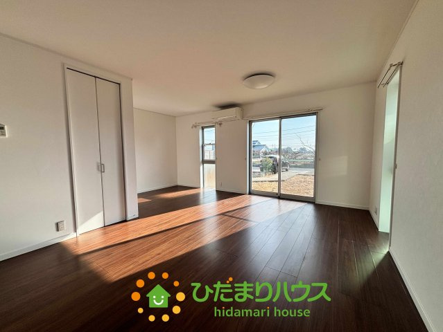 加須市南小浜　中古一戸建ての居間・リビング|見てください、この圧倒的な日当たり！二面採光の大きな窓から陽光がたっぷり降り注ぎ、濃いブラウンの床に美しく反射しています。広々とした空間は、家族でゆったりとくつろぐ団らんのひとときにいいですね♪