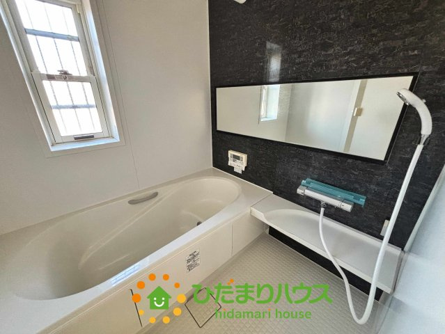 加須市南小浜　中古一戸建ての浴室|落ち着いたアクセントパネルが高級感を演出する一坪サイズの浴室です！ゆったり浸かれるバスタブと横長の鏡が空間を広く見せ一日の疲れを癒やすリラックスタイムを叶えます。換気に便利な窓があるのも嬉しいポイント