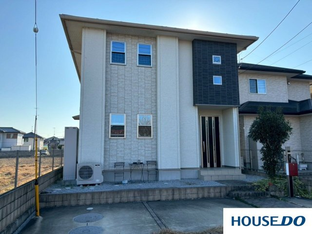 中古戸建　台之郷町の外観|晴れた青空の下で、白い部分の外壁が光を受けて明るく見え、清潔感と開放感があります