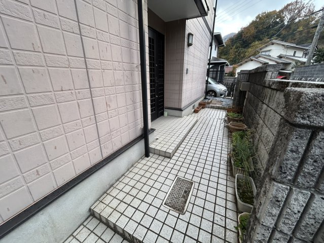 安佐北区亀山南3丁目　土地建物の玄関|タイル敷きのアプローチが清潔感のある印象を与える玄関まわりです。ゆとりあるスペースで歩きやすく雨の日