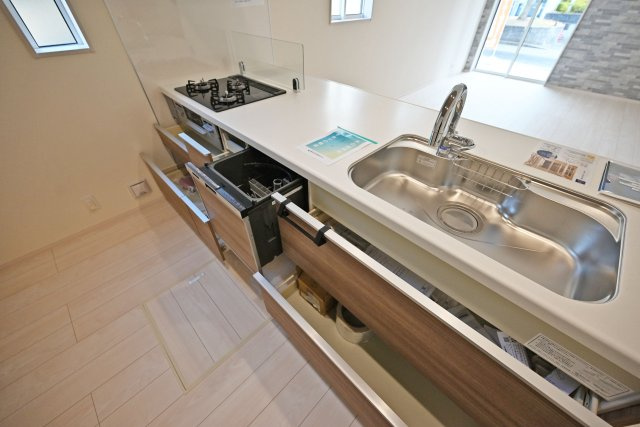 ブルーミングガーデン泉町新築一戸建て│3LDK+駐車2台可(車種制限有)のキッチン|ワークトップは十分な広さがあるW2550タイプ。調理台下いっぱいに収納を設け、包丁のホルダーや調味料専用の引き出しも備えています。本分譲地は食洗機が標準装備されています。