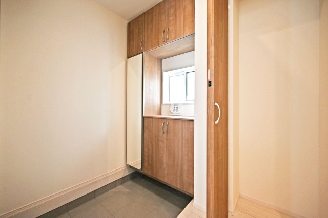 ブルーミングガーデン泉町新築一戸建て│3LDK+駐車2台可(車種制限有)の玄関|1階玄関をホール側から撮影した内観写真です。 シンプルな玄関扉にシューズボックス、小窓を配置したオーソドックスな玄関です。