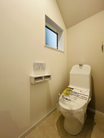 【トイレ】 | 東淀川区北江口4丁目新築戸建 | 温水洗浄便座完備の洋式トイレ。手元で操作できる壁面リモコンで快適な使い心地。
