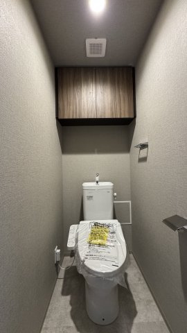 ネベル北四番丁　priéreのトイレ|TOTO便器＋ウォシュレットを使用。吊戸棚も設置されているので、トイレットペーパーなどの収納に便利です。　※家具・小物（調度品）は販売価格に含まれません。
2025年2月撮影