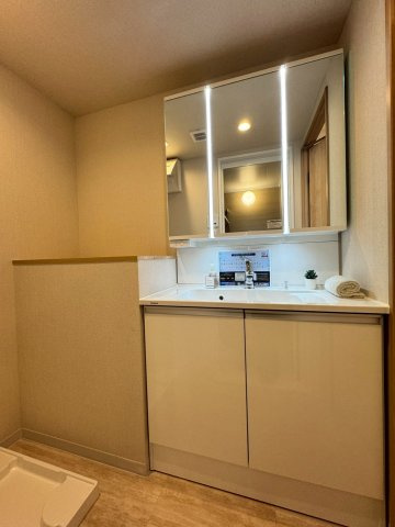 高殿コーポの独立洗面台|明るい三面鏡を備えた洗面化粧台。横にはカウンター付きで日用品も置くことができます。