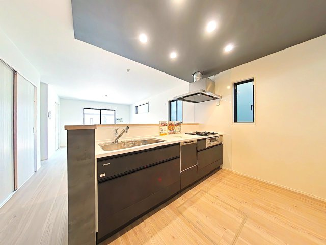岡山市南区泉田1丁目2期2号棟のキッチン|対面式のオープンキッチンです。ダウンライトで明るくなっています。
