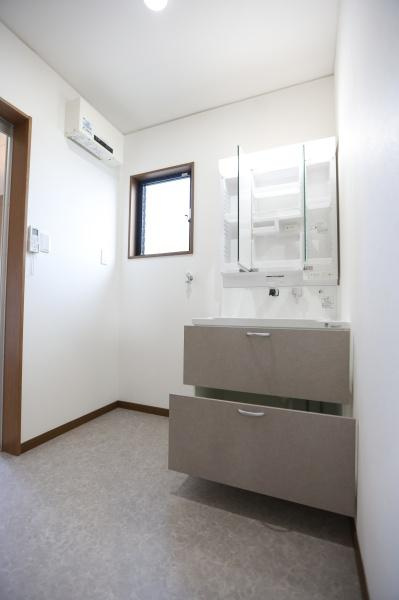 横田　中古の独立洗面台|明るい洗面所には大きな鏡付きの洗面台が設置されています。収納力のある引き出し式の収納で整頓がしやすいです。