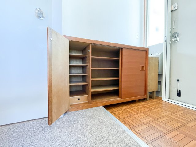 御影野村ハイツの玄関|木製の靴箱が設置されている玄関はどこか懐かしさを感じる温かみある空間です。外観や建物全体の雰囲気と調和されており、素敵な物件です。