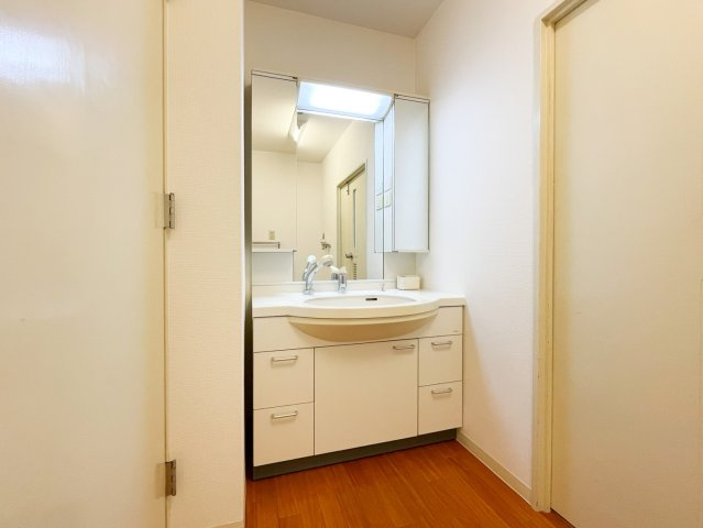 御影野村ハイツの独立洗面台|洗面台は収納が充実しており、広々とお使いいただけるサイズです。三面鏡とシャワー付き水栓は朝の忙しい時間に嬉しいですね。