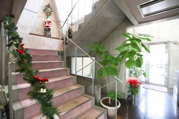 八幡店舗付中古の内装|開放感のある階段スペースに明るい日差しが差し込んでいます。コンクリートの壁面がモダンな印象を与えます。観葉植物を置いたり、季節の小物で楽しい雰囲気を味わえそうな空間です。