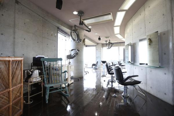 八幡店舗付中古の洋室|開放感があり、広々とした設計が特徴です。大きな窓から自然光が差し込み明るい空間が印象的です。コンクリート調の壁面と黒のフローリングが調和しています。