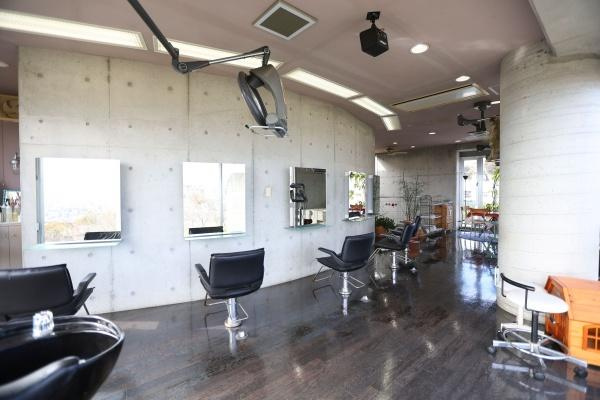 八幡店舗付中古の内装|コンクリート打ちっぱなしのスタイリッシュな内装が特徴の理容室です。大きな窓からは自然光がたっぷり入り店内を明るく保っています。