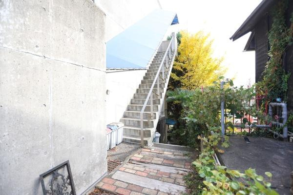 八幡店舗付中古のその他|屋外に設けられたコンクリート階段はシンプルで実用的なデザインです。明るい外観は清潔感を感じさせます。植栽とのコントラストが特徴的で落ち着いた雰囲気を演出します。十分な幅の階段で昇降しやすい設計です。