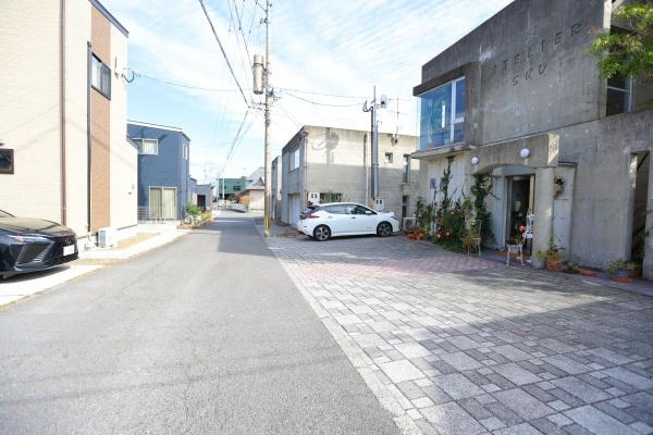 八幡店舗付中古の前面道路含む現地写真|前面道路は広々としており交通の通行もスムーズ。すっきりとした街並みです。周辺には建物が並び落ち着いた雰囲気が感じられます。