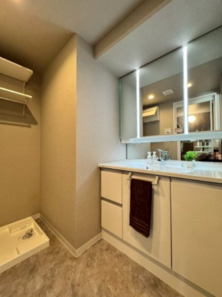 寝屋川東ファミリータウン北一番館の独立洗面台|ツインライン照明がお洒落な三面鏡付きの洗面台。
下部収納も充実です。