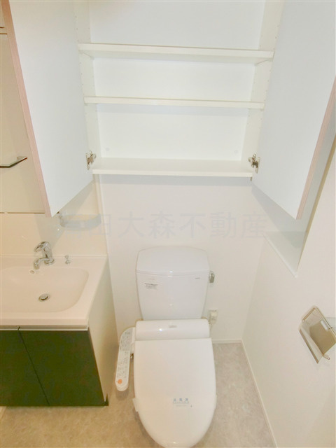 ジーベック平和島のトイレ|上部吊戸棚と温水洗浄便座付きのトイレ