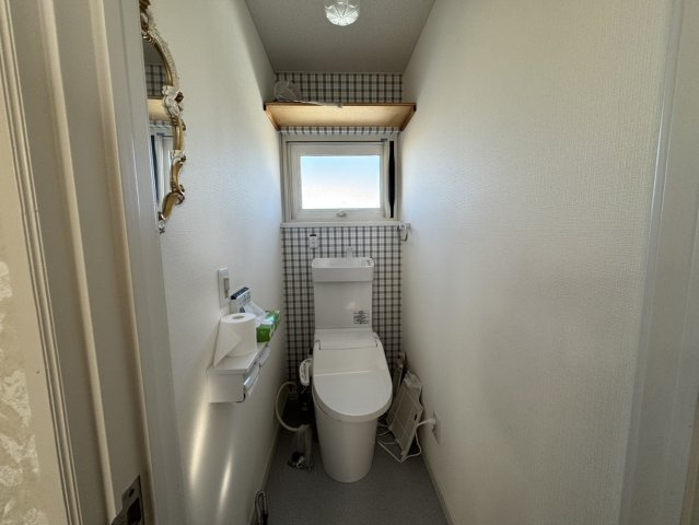 吹抜け×元カフェ♪【釧路町中央4丁目】大容量収納の広々40坪住宅！のトイレ|窓付きで明るい！お洒落なクロスと棚付きトイレ！
