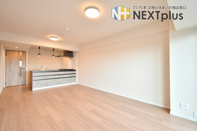 ソフィア上尾B棟の居間・リビング|LDKは奥行きのある広々設計で、ソファやテレビボードを置いても動線にゆとり。壁面が長く収納家具や飾り棚のレイアウトもしやすいです。照明も複数あり、食事・くつろぎなどシーンに合わせて使えます。