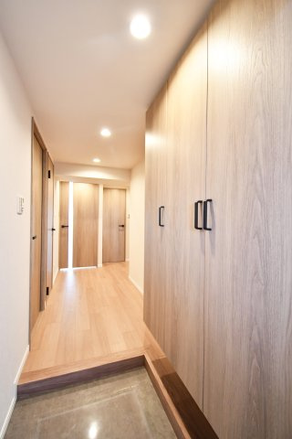 ソフィア上尾B棟の玄関|玄関から続く廊下は幅に余裕があり、出入りがスムーズ。壁面収納も確保されているので日用品や防災用品の置き場にも便利。明るい床色で室内全体が広く感じられ、移動もしやすい設計です。生活動線◎。