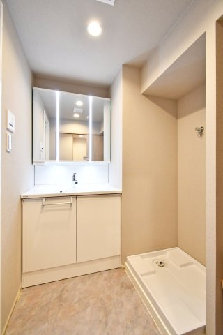 ソフィア上尾B棟の独立洗面台|洗面室は三面鏡付きの洗面化粧台で身支度がはかどります。横に洗濯機置場を確保し、ボウルまわりも広め。カウンター下収納も使いやすく、タオルや洗剤類をまとめて整理できる空間です。動線も良好です。