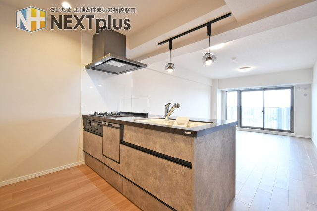 ソフィア上尾B棟のキッチン|キッチンはリビングを見渡せる対面式で、家族と会話しながら料理が楽しめます。手元を隠せる立ち上がりとペンダント照明で雰囲気も◎。水栓やシンクも使いやすく、家事がはかどるレイアウトです。