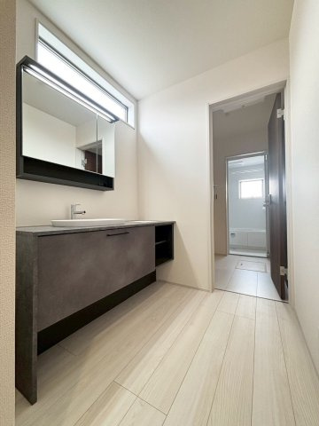 深谷市上野台　第24　新築一戸建て　リーブルガーデン　02の独立洗面台|朝の忙しい時間帯でも準備がスムーズに行える、ワイドな三面鏡付きの洗面化粧台です！小窓から自然光が入り、明るく清潔感のある空間。足元や鏡の裏には洗面用具や小物をたっぷり収めて綺麗に保てます♪