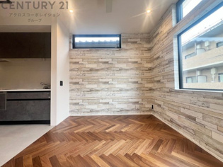 大きな採光窓から光が差し込む、明るく開放的なリビング。ヘリンボーンの床材が上質な雰囲気を添え、日々の暮らしを心地よく彩ります。