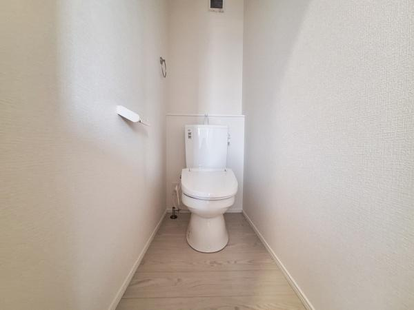 横塚2丁目1期1号棟のトイレ|シンプルな内装で清潔感のあるトイレです。
壁紙とフローリングの色合いが調和しています。

