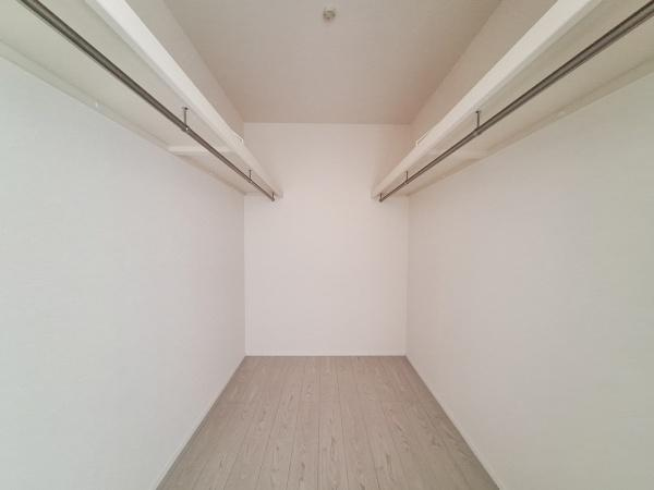 横塚2丁目1期1号棟の収納|ゆったりとしたスペースが広がる収納エリアです。両側にハンガーパイプが備え付けられており衣類や小物をきれいに整理できます。シンプルな内装なので使い方のアレンジもしやすい収納です。