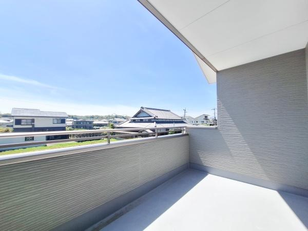 横塚2丁目1期1号棟のバルコニー|広々としたバルコニーで開放感のある空間が広がっています。周囲の景色も楽しめる見晴らしの良いバルコニーです。日当たりも良好なので洗濯物もよく乾きます。屋根があるため天候の変化にも対応しやすい設計です。