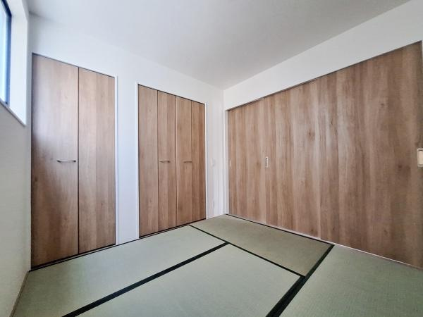 横塚2丁目1期2号棟の和室|落ち着いた雰囲気の和室です。木目調の建具が空間に温かみを与えています。大容量の収納スペースも備わっています。窓からの自然光も確保されています。使い勝手の良い和室となっています。