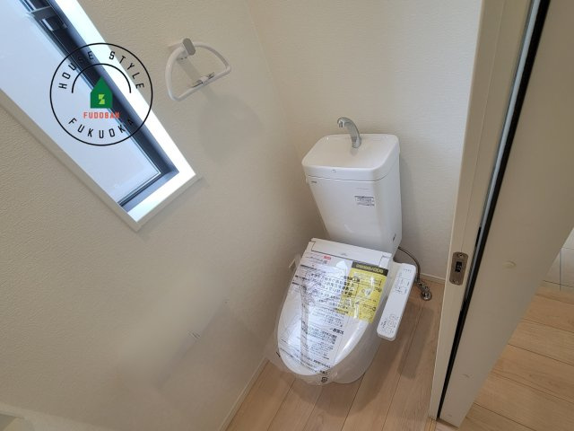 春日市一の谷1丁目第8-4棟（4号棟）の内観：施工例|トイレ・ウォシュレット付。快適で衛生的な洗浄機能付温水シャワートイレです。収納や手すりもついてます。