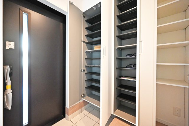 西宮市甲子園口5丁目新築一戸建て│4LDK+駐車1台可の玄関|1階玄関を廊下側から撮影した内観写真です。 収納庫内は可動棚になっているので靴のサイズに合わせて棚の高さを変更できます。