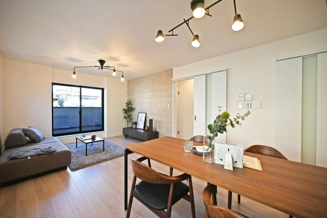 西宮市甲子園口5丁目新築一戸建て│4LDK+駐車1台可の居間・リビング|対面式キッチンで家族同士のつながりを感じやすい設計を基調としています。折下天井やアクセントクロスを設けるなど、デザイン性を向上させた内観に仕上がりました。