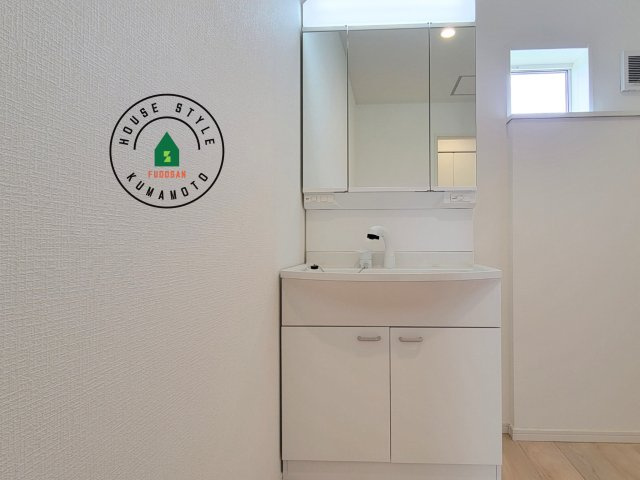 熊本市北区清水新地2丁目第6-2棟（1号棟）の内観：施工例|毎日使うものだから清潔な空間を保ちたい水回り。洗面にはそんな願いを解消させてくれる収納アイデアが満載です。三面鏡の裏側にはキャビネットが現れ小物から背の高い物まで収納できます。