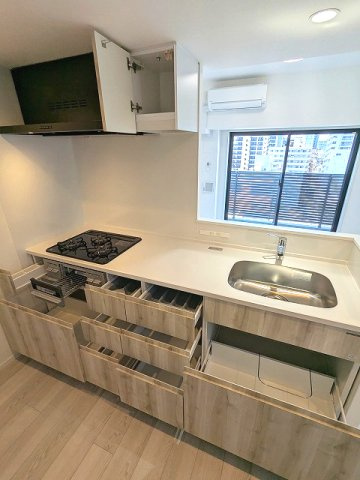 エスレジデンス浅草clarityのキッチン|グリル付ガス3口システムカウンターキッチン、奥の物も取り出しやすいスライド収納、瀟洒でお手入れ楽なガラストップコンロです、広々のシンクです