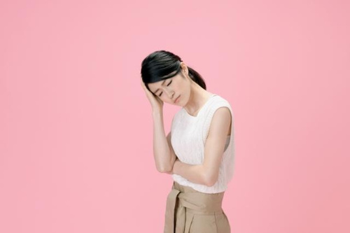 頭を悩ませる女性の写真