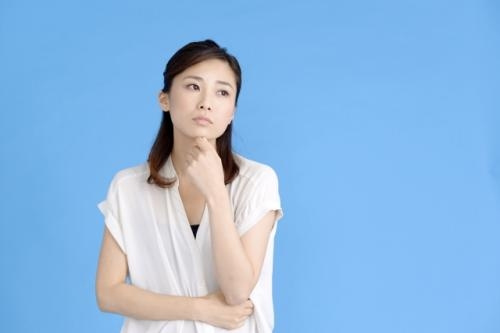 女性が首をかしげながら、あごに左手をやる写真