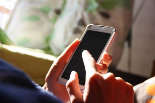 スマホの画面を指で触ろうとしている写真