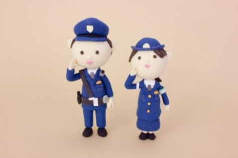男女の警察官２体の人形が敬礼している写真