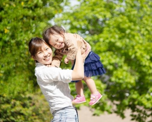 お母さんが子どもを「高い高い」している写真