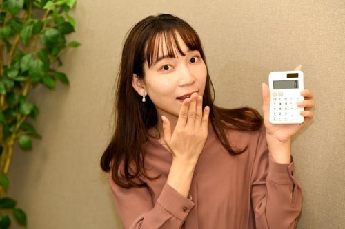 電卓を持った女性がビックリしている写真