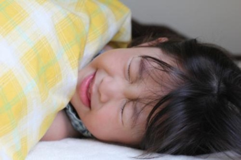 布団に入っている子どもが苦しそうにしている写真