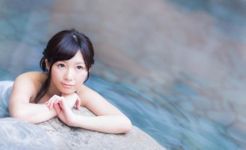 温泉に入っている女性が遠くを見つめている写真