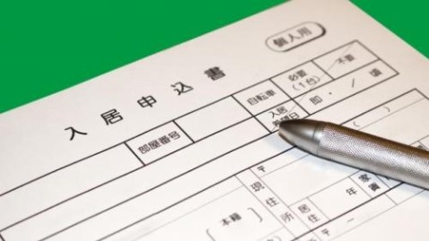 入居審査の時間を短くするためにびっしりと申込用紙を書き込もうとする写真