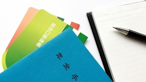老後の１人暮らしのために年金手帳や通帳の中を確認している写真