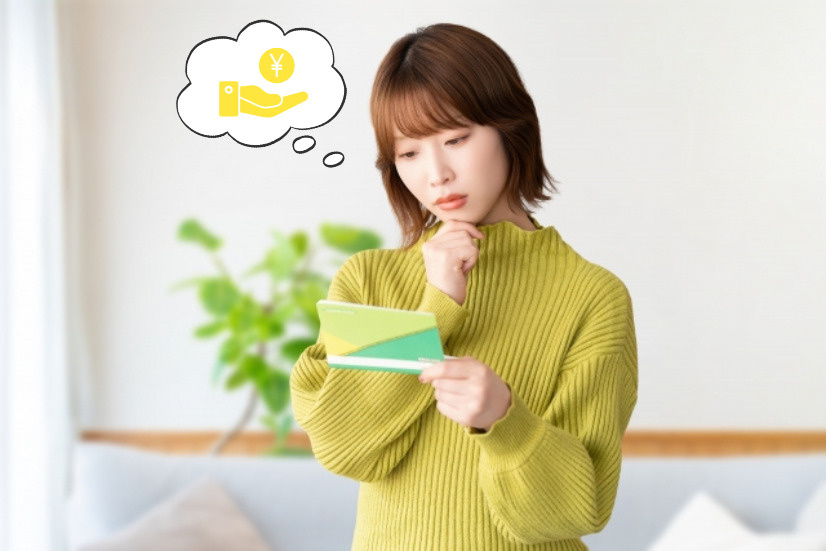 通帳を見て考え込む女性