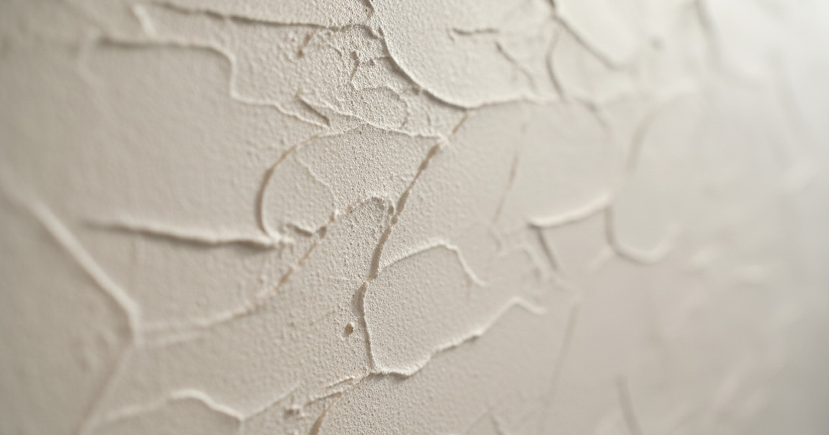 漆喰の壁に映る柔らかな光と影、職人の手仕事を感じるテクスチャ